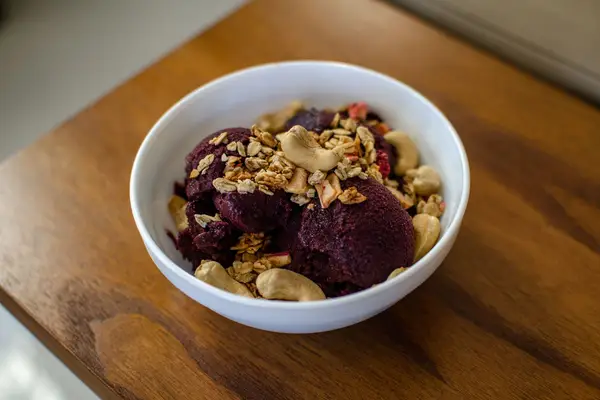 Tigela de açaí com frutas e granola sobre o balcão