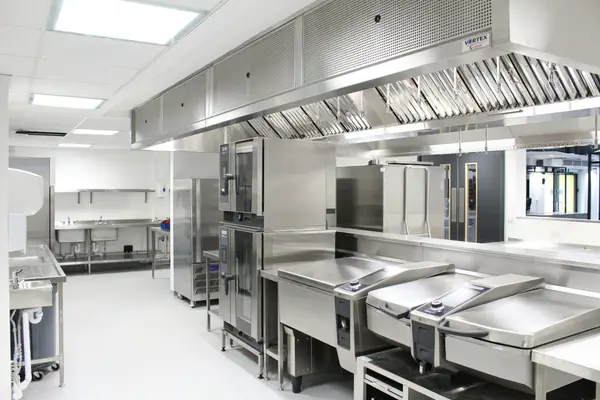 Cozinha industrial com panelões e bancadas em inox