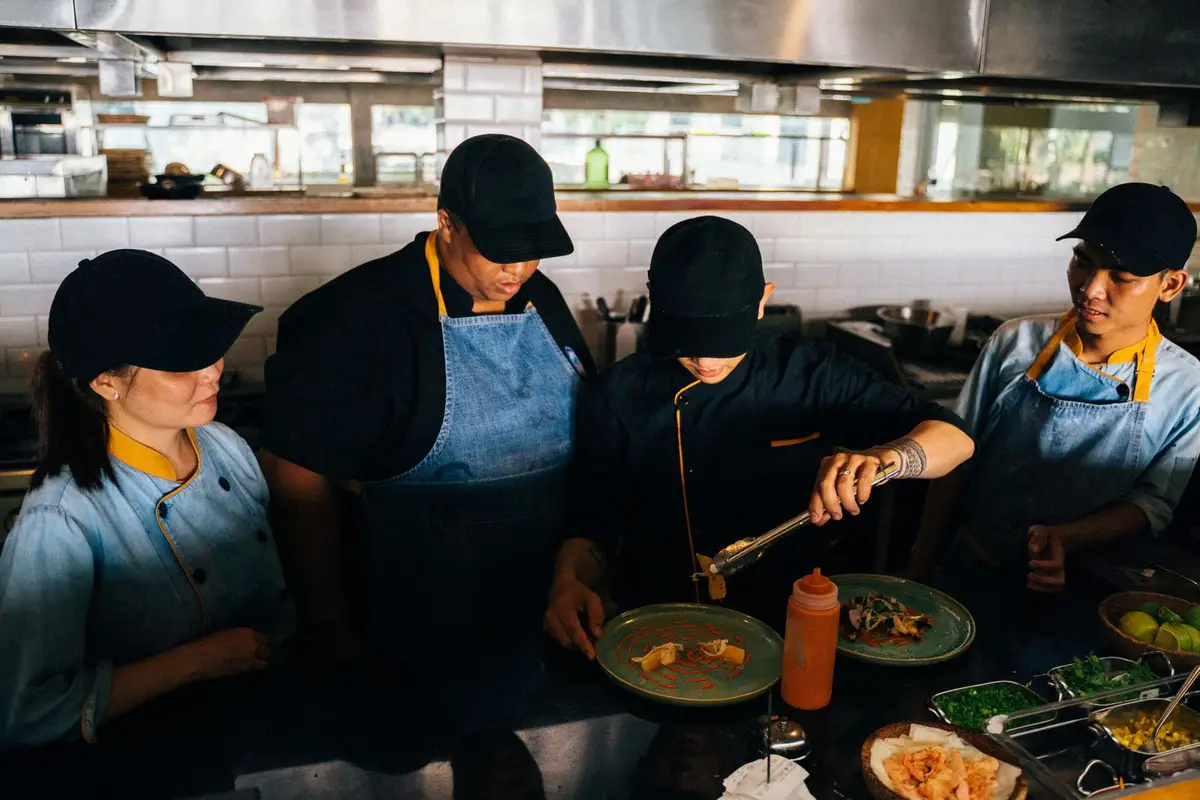 Equipe de cozinha finalizando pratos na linha do restaurante